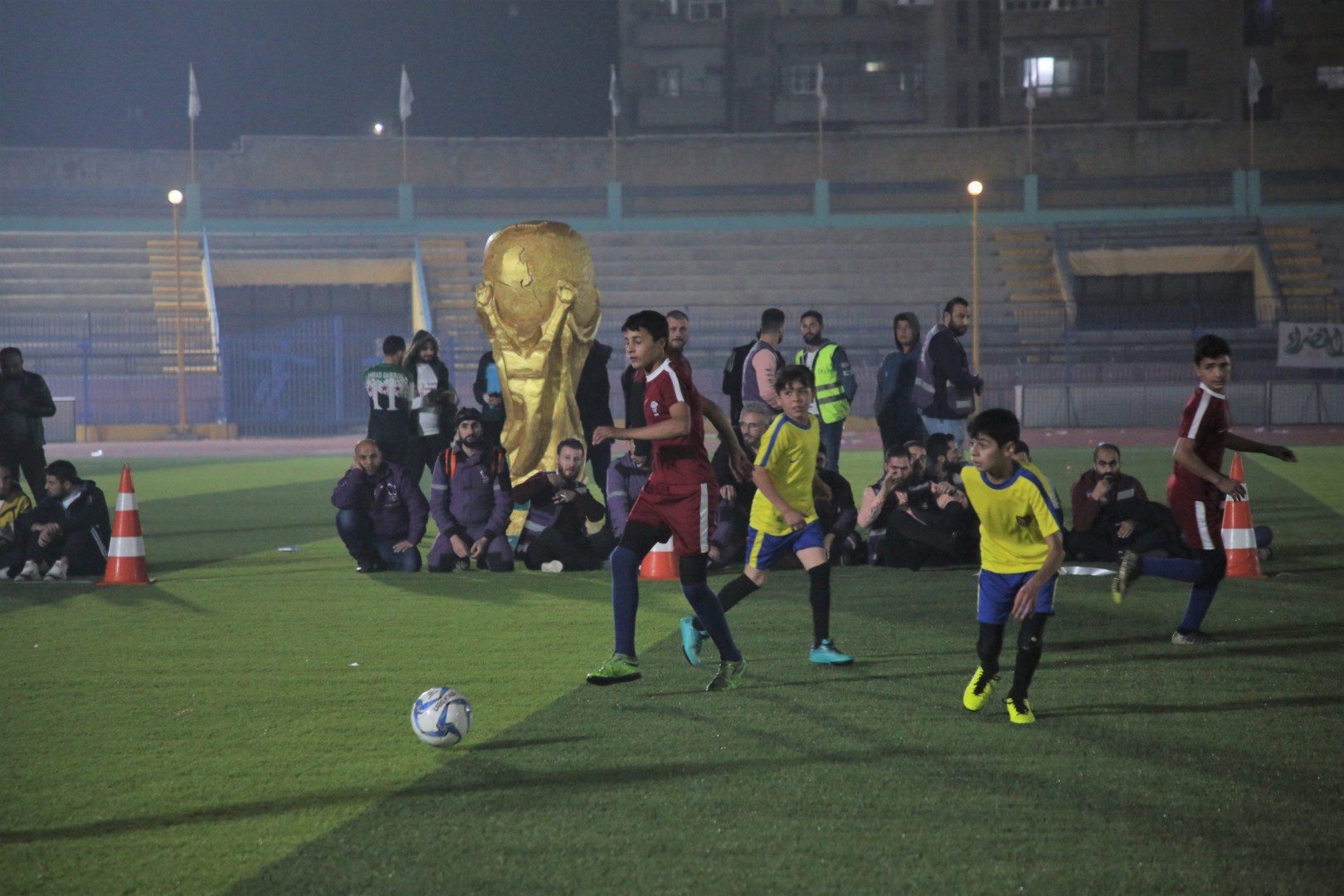 أطفال يشاركون في المباراة الافتتاحية لكأس العالم للمخيمات في إدلب، التي جمعت قطر بالإكوادور، 19/ 11/ 2022 (محمود حمزة)