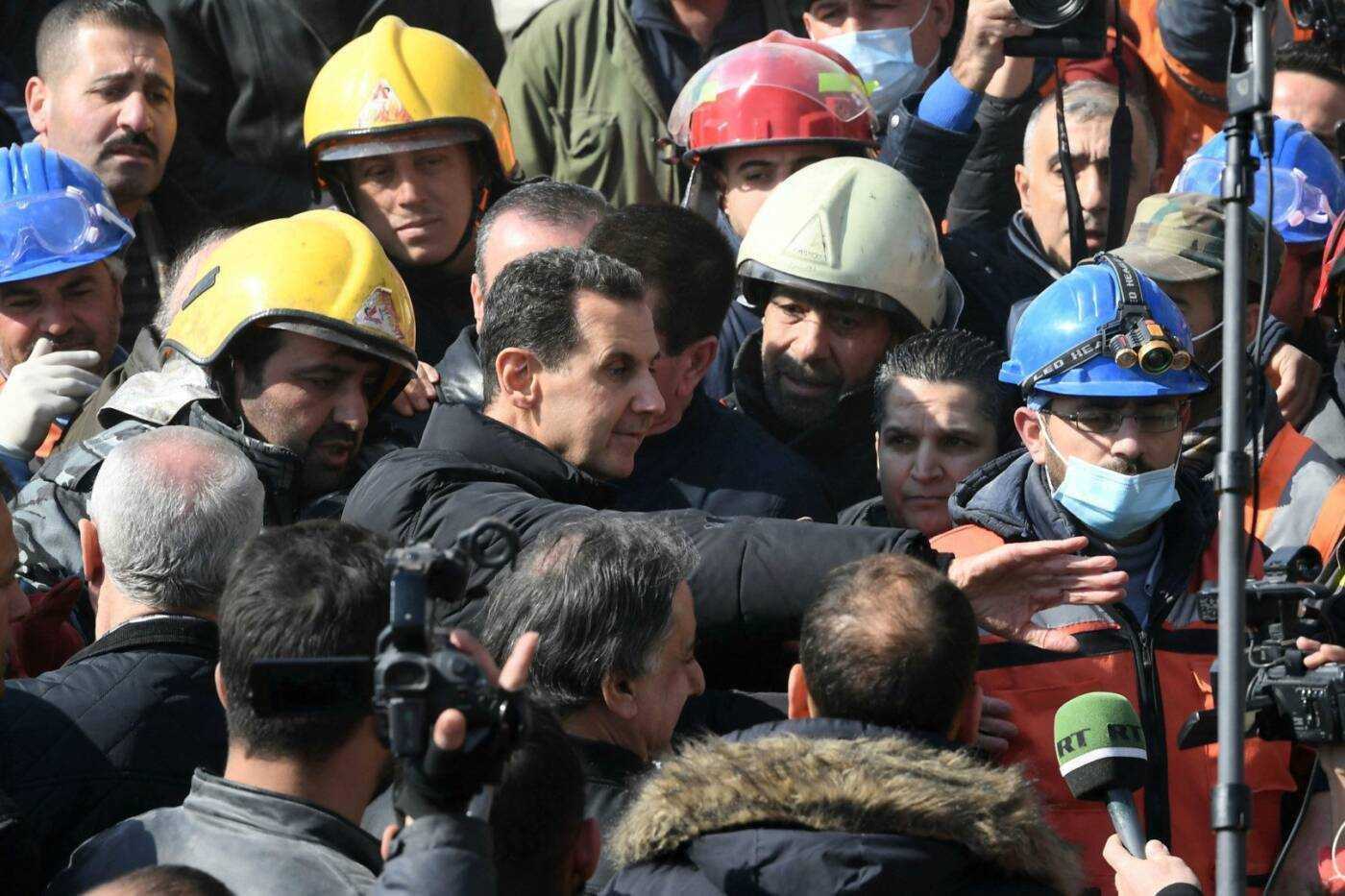 بشار الأسد يتوسط مجموعة من الناس أثناء زيارته للمتضررين من الزلزال في مدينة حلب، 10/ 02/ 2023، (أ ف ب)