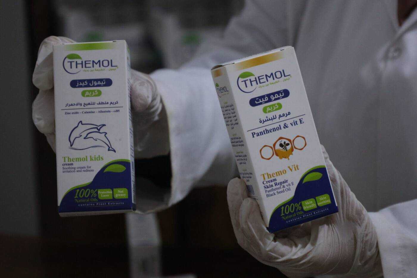 صفاء الموسى تحمل صنفين من منتجات شركتها تيمول، 17/ 08/ 2023، (أحمد الأطرش/ سوريا على طول)Safa al-Mousa holds two of her Idlib-based medical skincare company’s products, 17/8/2023, (Ahmad al-Atrash/Syria Direct)