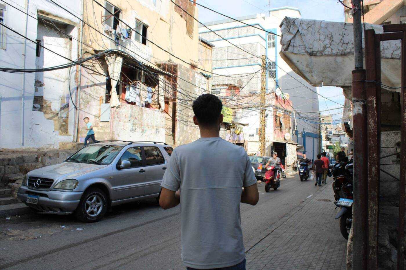 Muhammad al-Hassan, 21, stands outside his home in Beirut’s Sabra refugee camp, 04/10/2023 (Hanna Davis/Syria Direct)محمود الحسن، 21  عاماً، في مخيم صبرا للاجئين بلبنان 04/ 10/ 2023 (هانا ديفيس/ سوريا على طول)