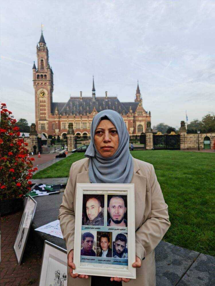 Yasmin Mashaan holds pictures of the five brothers she lost in Syria—four of whom were killed, forcibly disappeared or tortured by the regime—outside the Peace Palace in The Hague as hearings began in a landmark torture case brought against Syria by Canada and the Netherlands on Tuesday, 10/10/2023 (Caesar Families Association/Yasmin Mashaan)ياسمين مشعان، التي فقدت أشقاءَها الخمسة في سوريا، أربعة منهم قُتلوا، أُخفوا قسرياً أو تعرضوا للتعذيب على يد النظام، تحمل صورهم أمام قصر السلام في لاهاي، في يوم بدء جلسات الاستماع في قضية تعذيب مفصلية رفعتها كندا وهولندا ضد سوريا، 10/ 10/ 2023، (رابطة عائلات قيصر/ ياسمين مشعان)