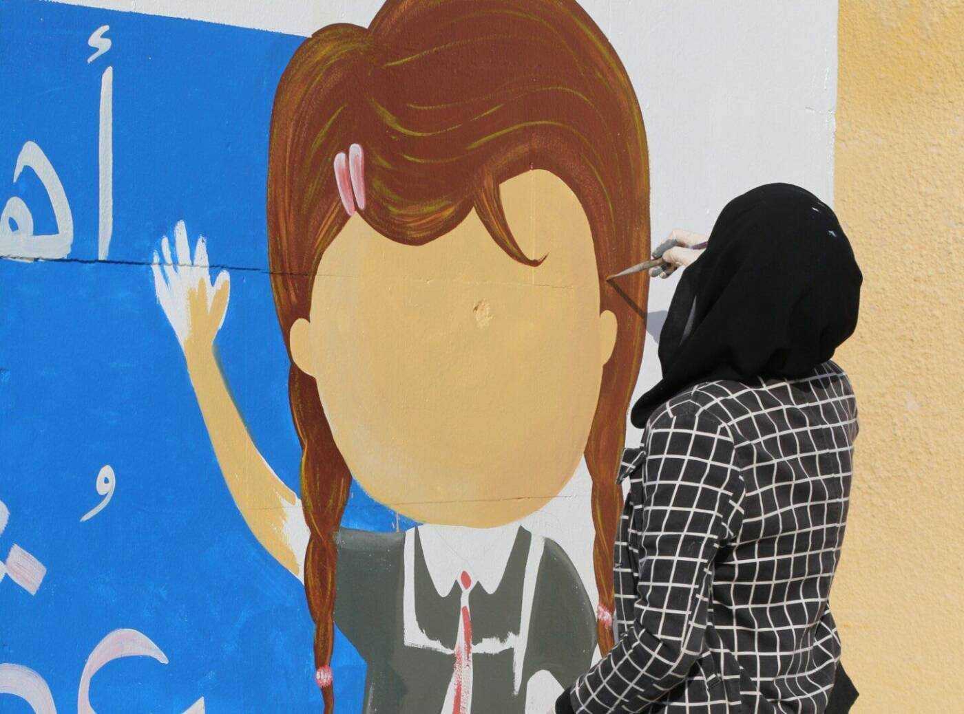 يافا دياب تنفذ رسم جرافيتي للأطفال في مدرسة بمدينة بنش، في ريف إدلب، 01/ 11/ 2021، (شقيقة يافا) Syrian artist Yafa Diab paints a mural on a school in Binnish, a city in Syria’s northwestern Idlib province, 11/2021 (Muhammad Diab)