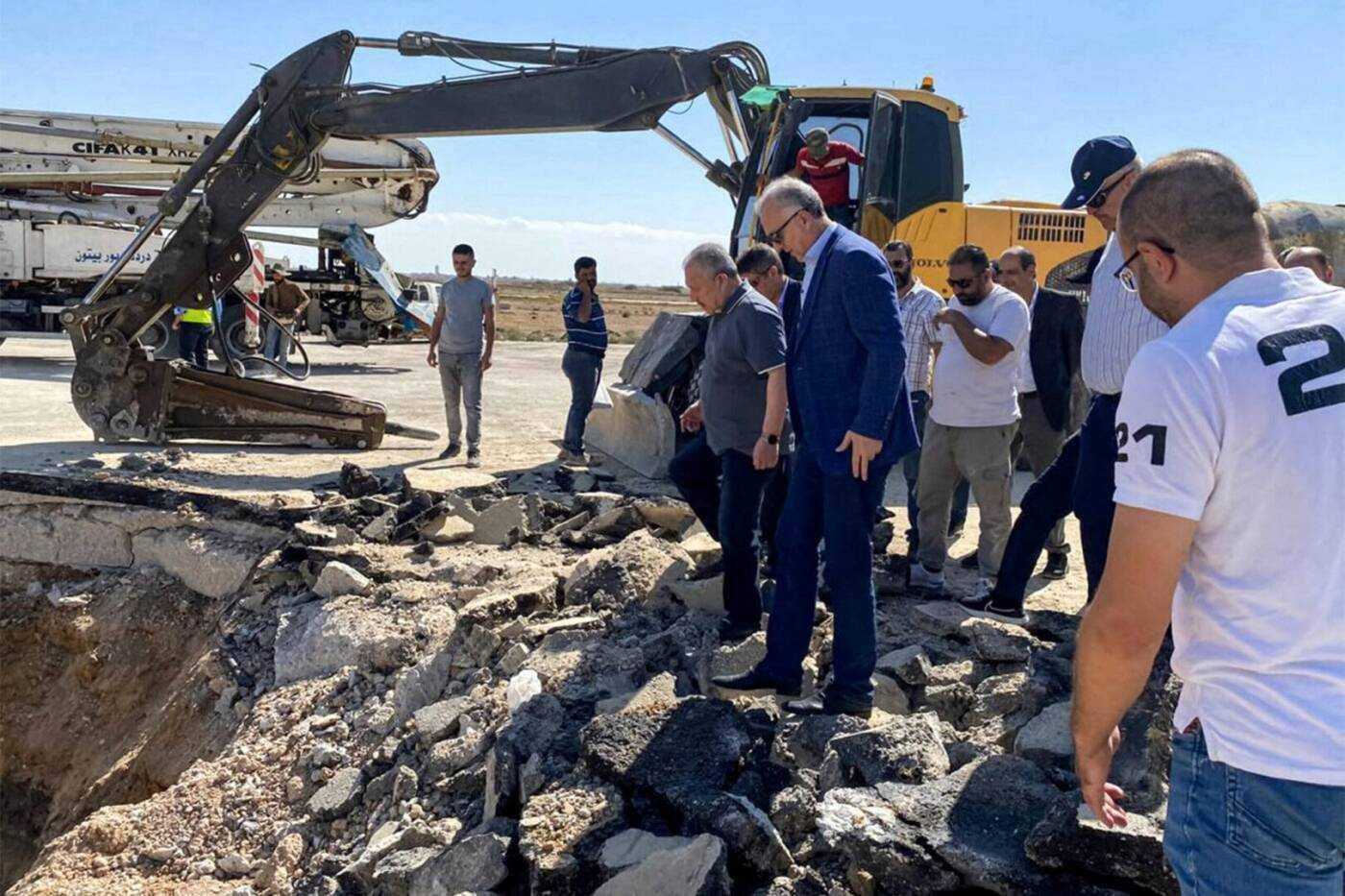 Syrian regime Prime Minister Hussein Arnous inspects damage caused by Israeli bombings of the Damascus International Airport’s runway, 10/13/2023 (AFP)