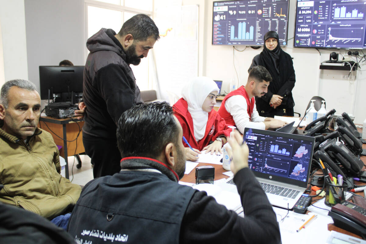 Mortad Mhanna (left of center, in black sweatshirt), the head of Tyre’s Disaster Management Union, coordinates aid distribution from his office, 16/01/2024 (Hanna Davis/Syria Direct)