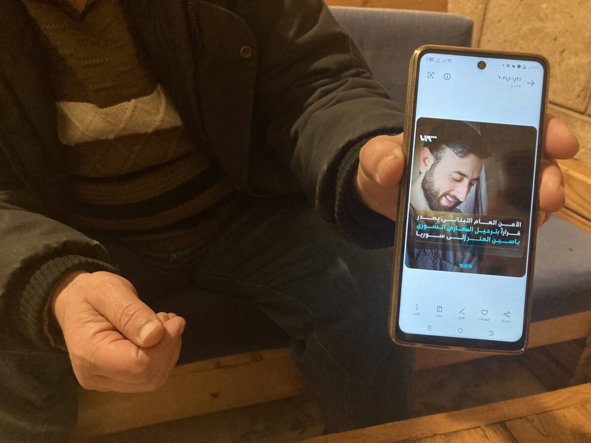 عبد الله (اسم مستعار)، يعرض صورة ياسين العتر، المهدد بالترحيل من لبنان، أثناء حديثه عن قريبه من مقهى في طرابلس، 31/ 01/ 2024، (هانا ديفيس/ سوريا على طول)