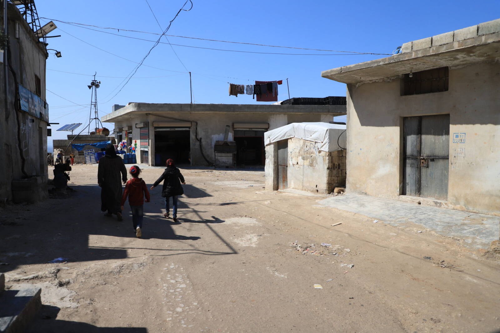 Shops at the entrance of the informal al-Jazira displacement camp, part of the Atma camps cluster on the border between Idlib and Turkey, 10/3/2024 (Abd Almajed Alkarh/Syria Direct)