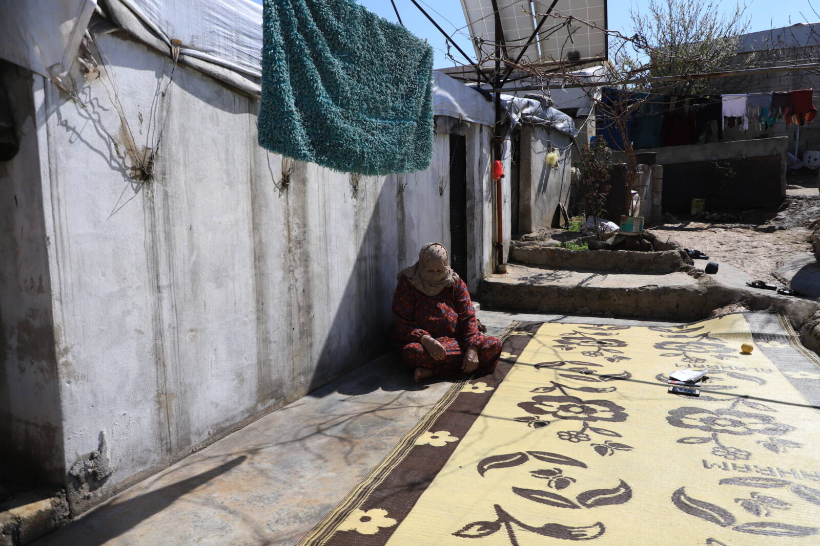 Kusiya Ahmad al-Qaws, 65, sits in front of her house in the Umm al-Shuhada camp in the Atma area of northwestern Idlib province, 10/3/2024 (Abd Almajed Alkarh/Syria Direct)