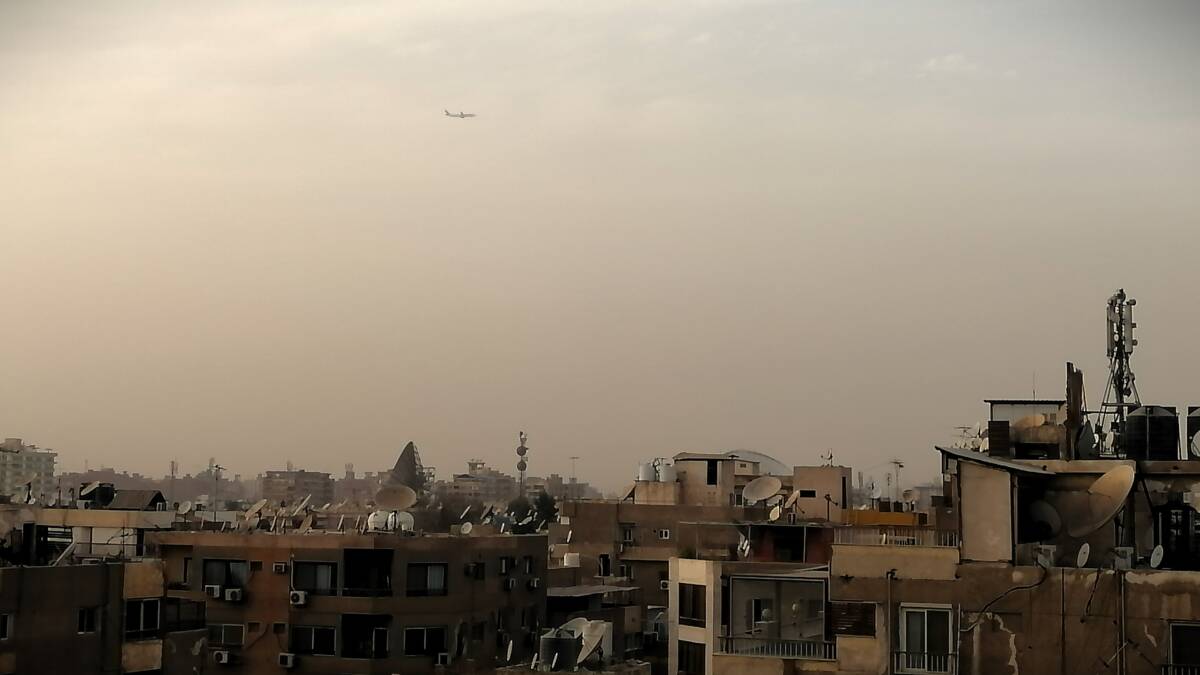جانب من مدينة القاهرة وتظهر من بعيد طائرة في سمائها تستعد للهبوط، 17/ 03/ 2024، (ليز موفة/ سوريا على طول)