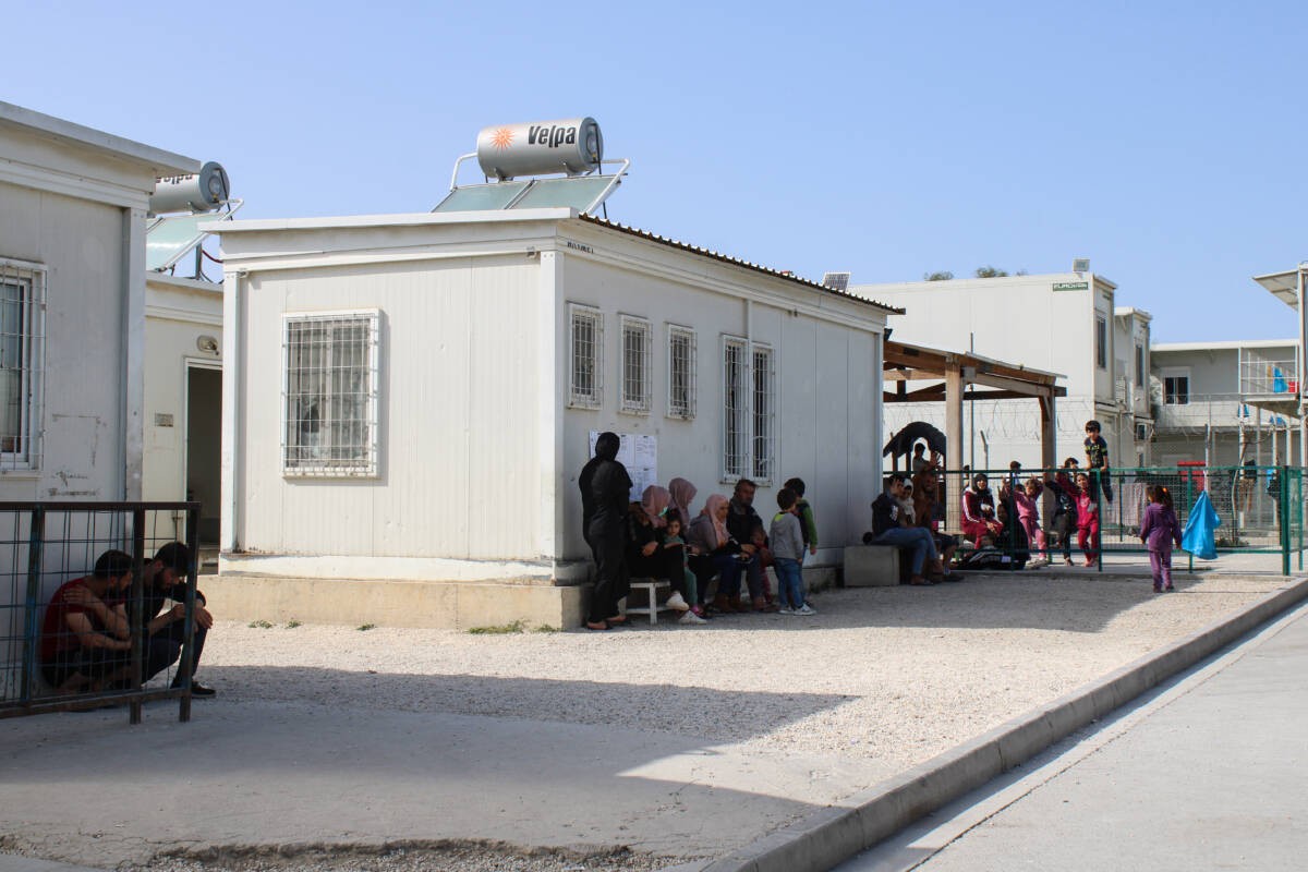طالبو لجوء واصلون حديثاً يستظلون من الشمس في مركز استقبال بورنارا بجزيرة قبرص، 27/ 03/ 2024 (هانا ديفيس/ سوريا على طول)