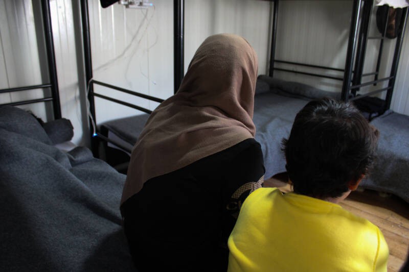Rihab al-Ahmad sits with one of her children inside her caravan at the Pournara Reception Center in Cyprus, 27/03/2024 (Hanna Davis/Syria Direct)